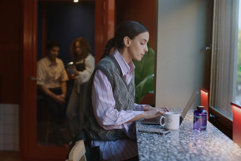 woman with a cup of coffee and a computer scandic go